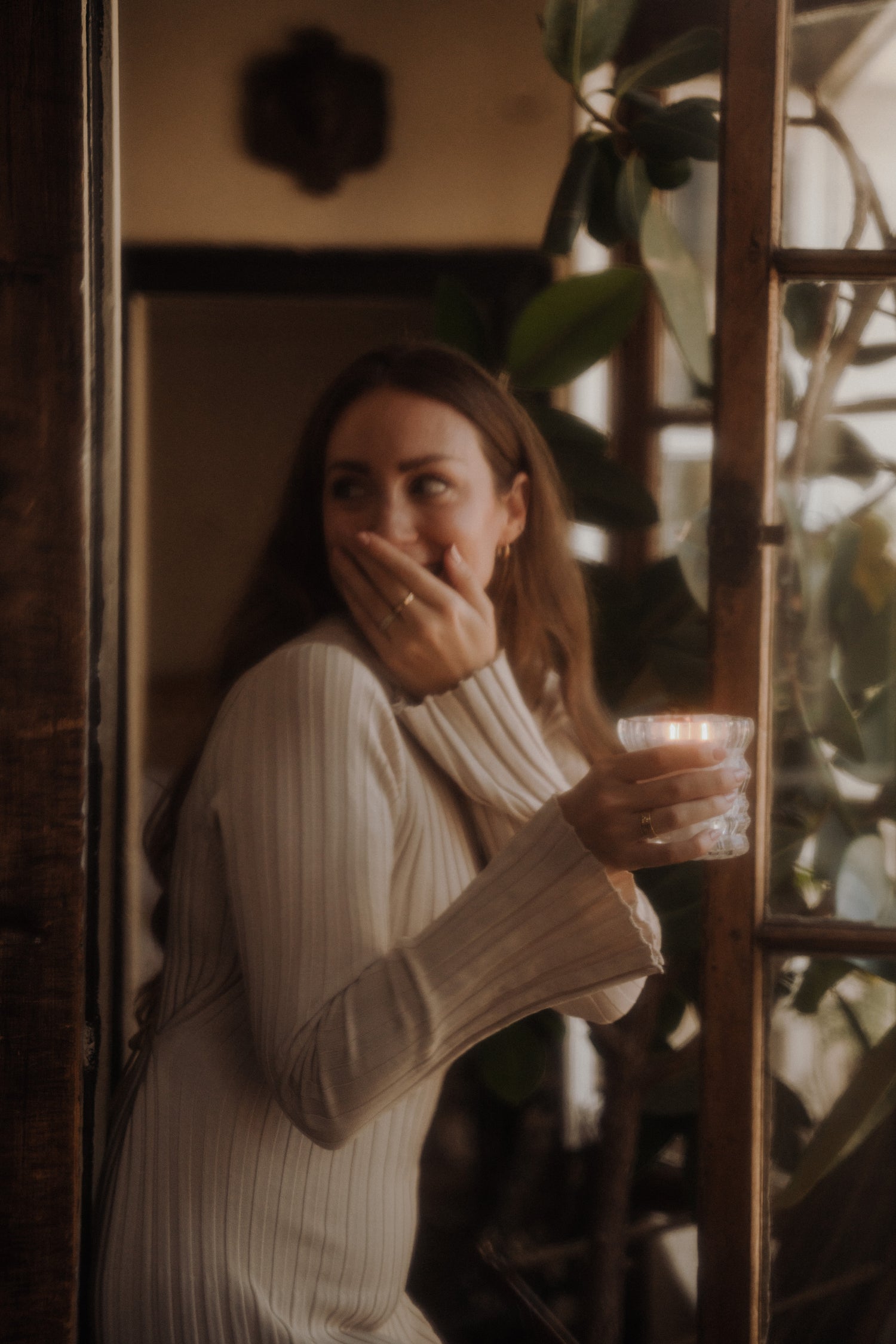 MaCenna Lee holds the lit Arlow candle, its flame softly glowing in her hands as she laughs.