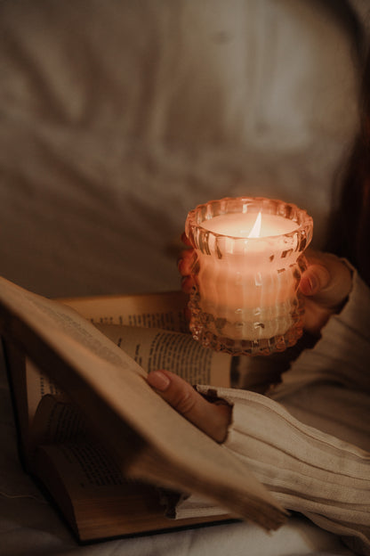 A book in one hand and the Arlow candle held in the other.