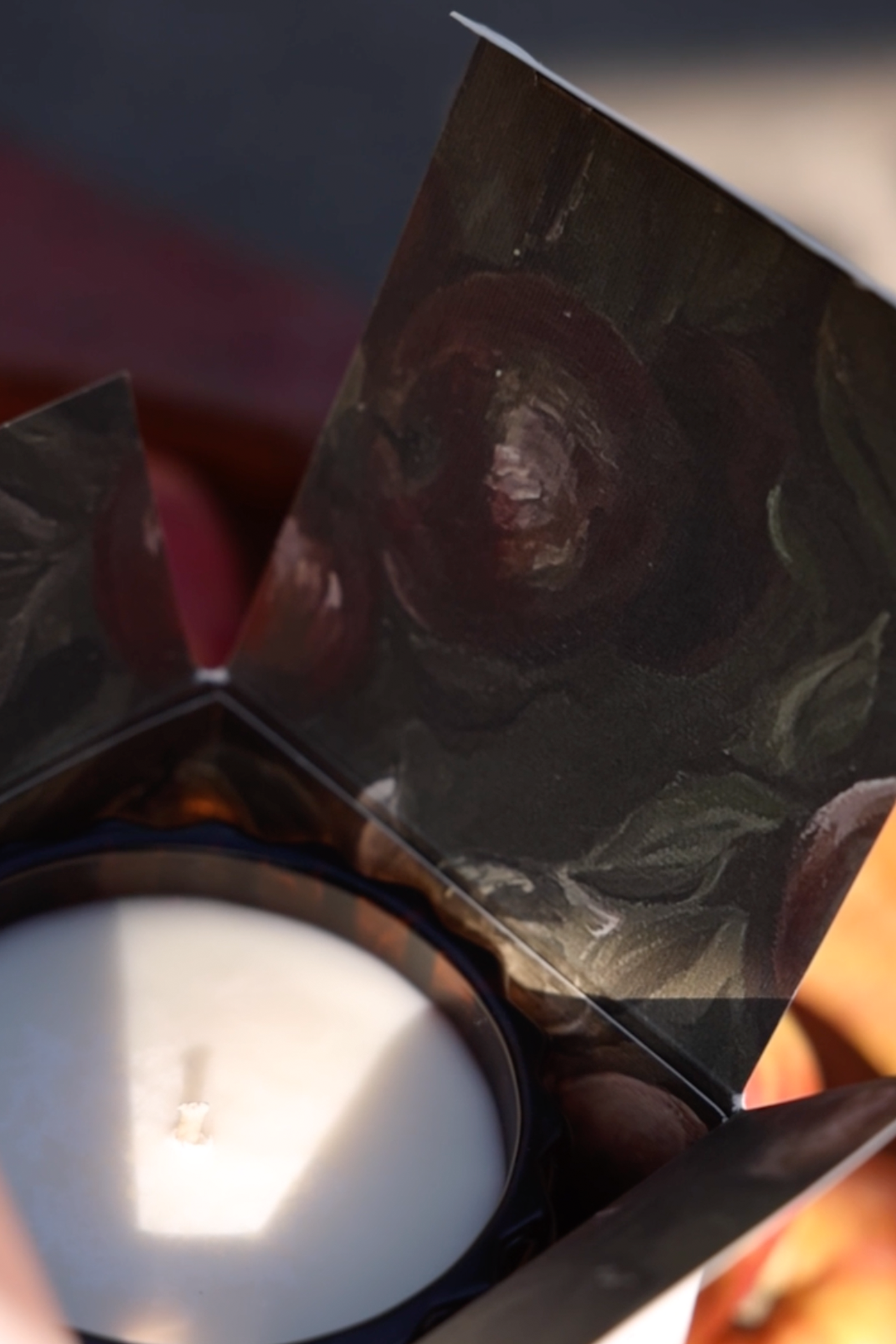 A close-up of the Autumne candle in its box, with the flap open to reveal the design inside.