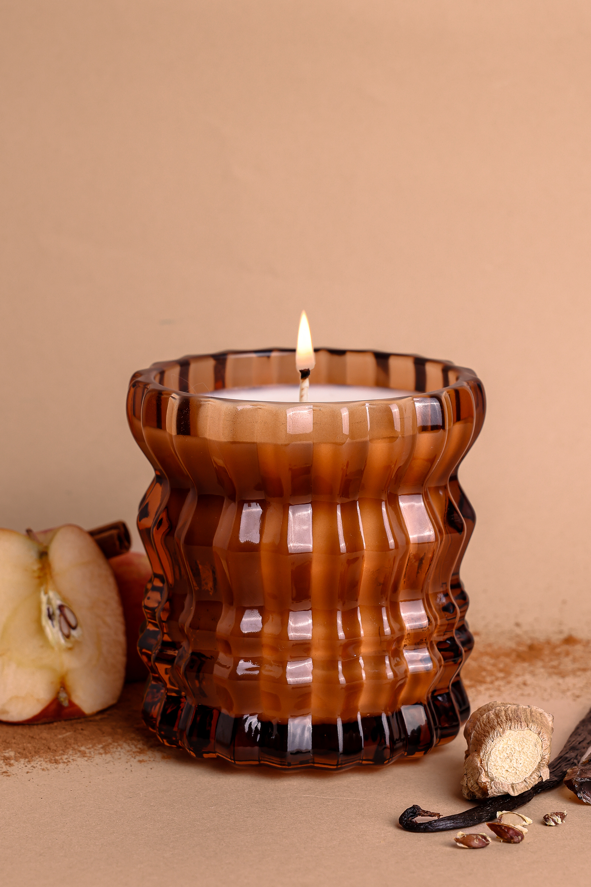 A close-up of the Autumnne candle with apples in the background, a key note in the scent.