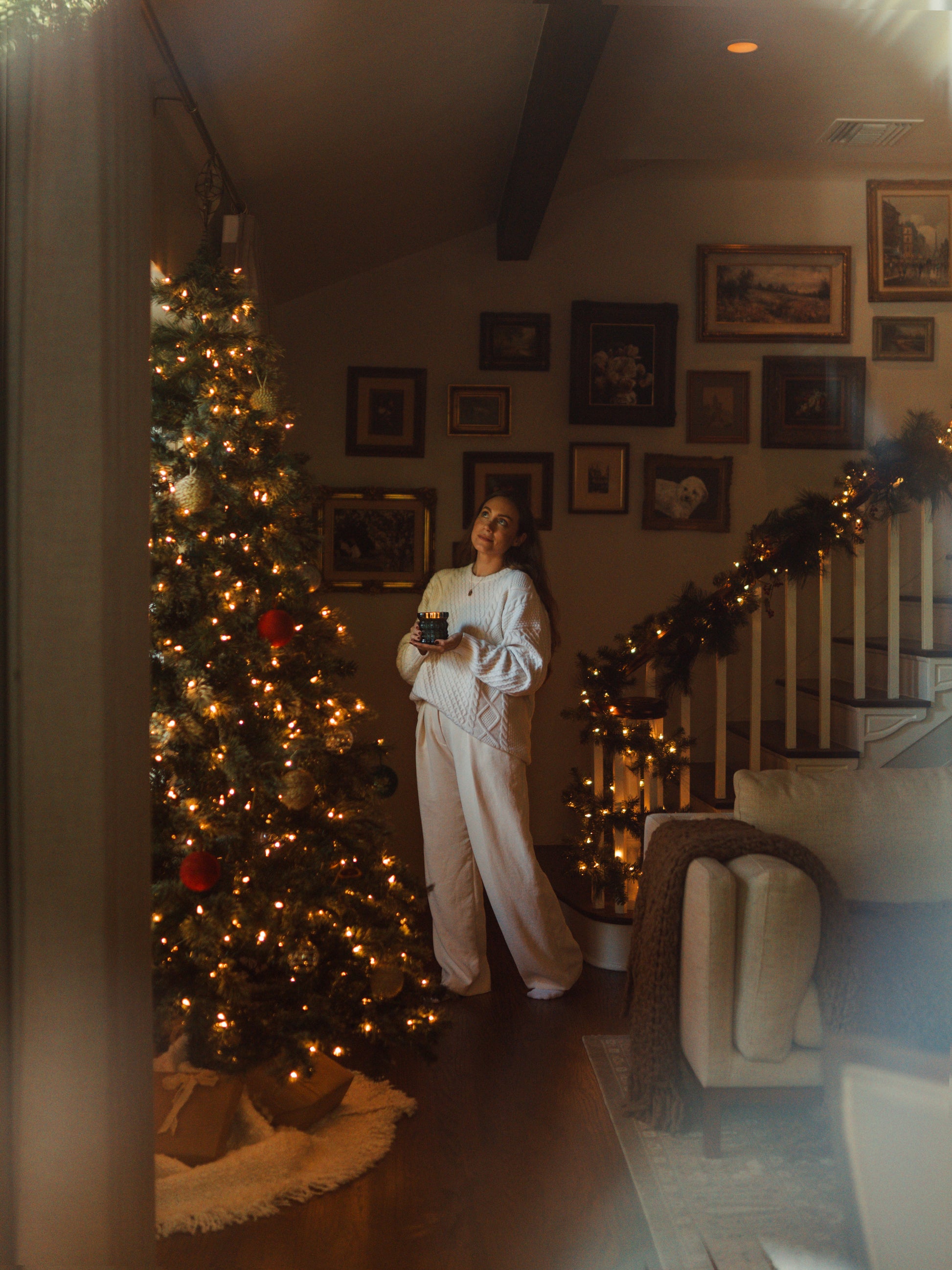 MaCenna Lee holds the Noel candle as she gazes up at the Christmas tree.