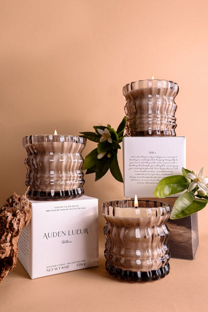 Three Willow candles are displayed with neroli and cedarwood, two key notes in the scent, alongside their signature packaging.







